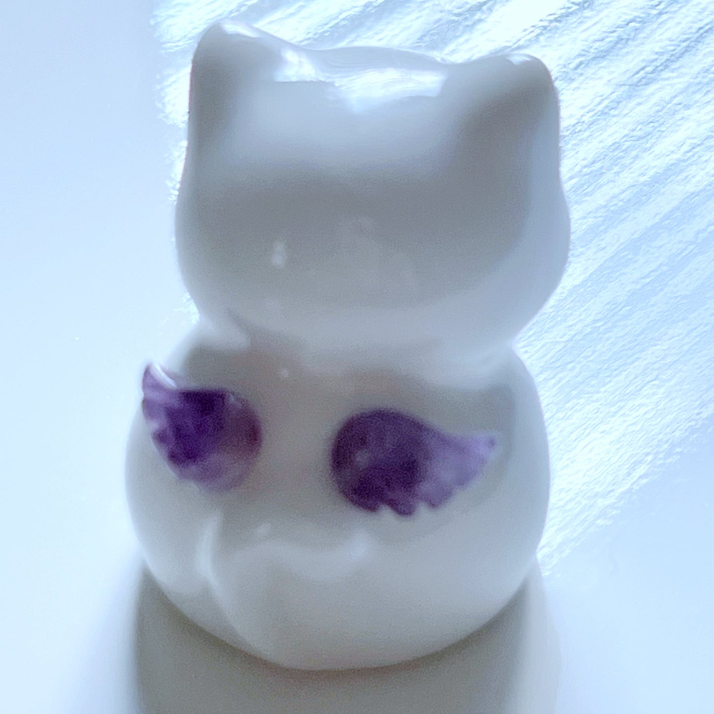 天然石を持ったなにとぞ猫