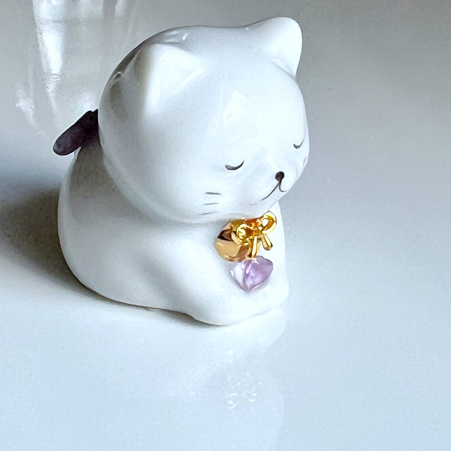 天然石を持ったなにとぞ猫