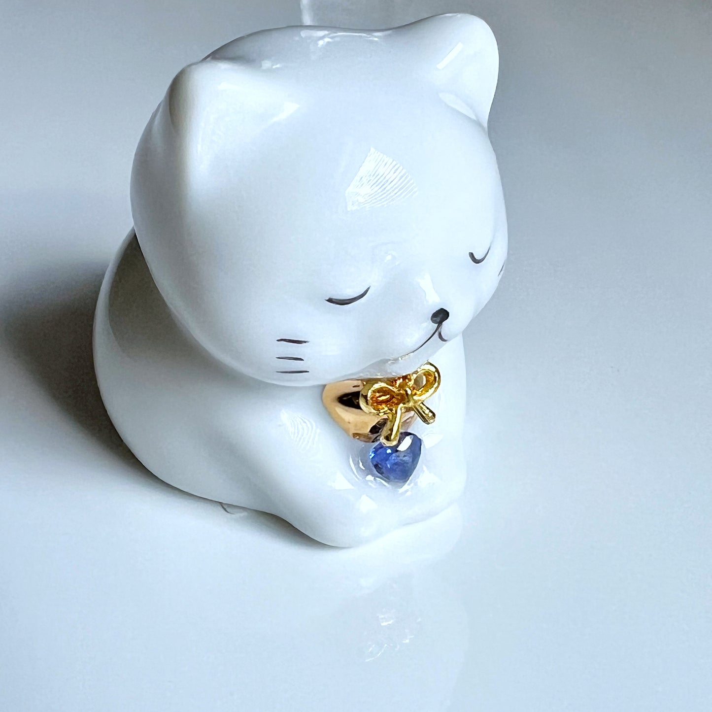 天然石を持ったなにとぞ猫
