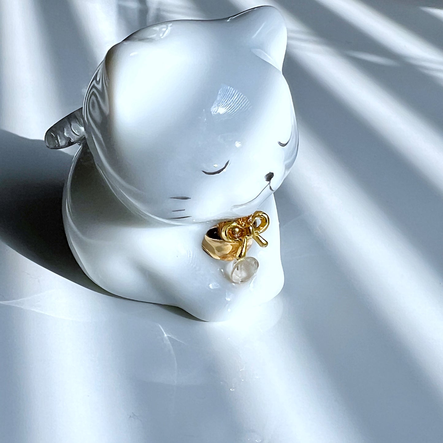 天然石を持ったなにとぞ猫