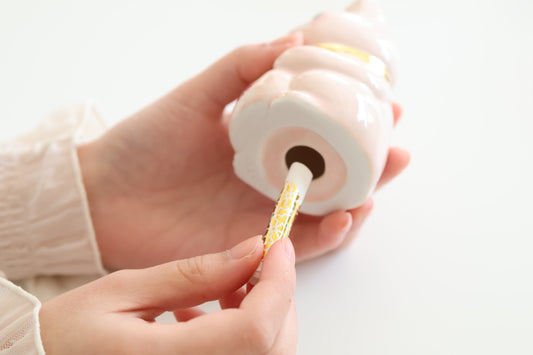 願いを書いた巻物をミラネコに入れる