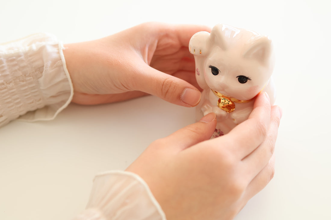 願いを書いた巻物を招き猫に託す